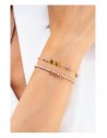 Bracciale Gipsy Chic fumé con tre medagliette indossato nella parte superiore del polso; il secondo bracciale non è incluso.